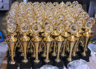 Le sportif attribuant la récompense en plastique met en forme de tasse des trophées, trophée de tasse de sports plaqué par or